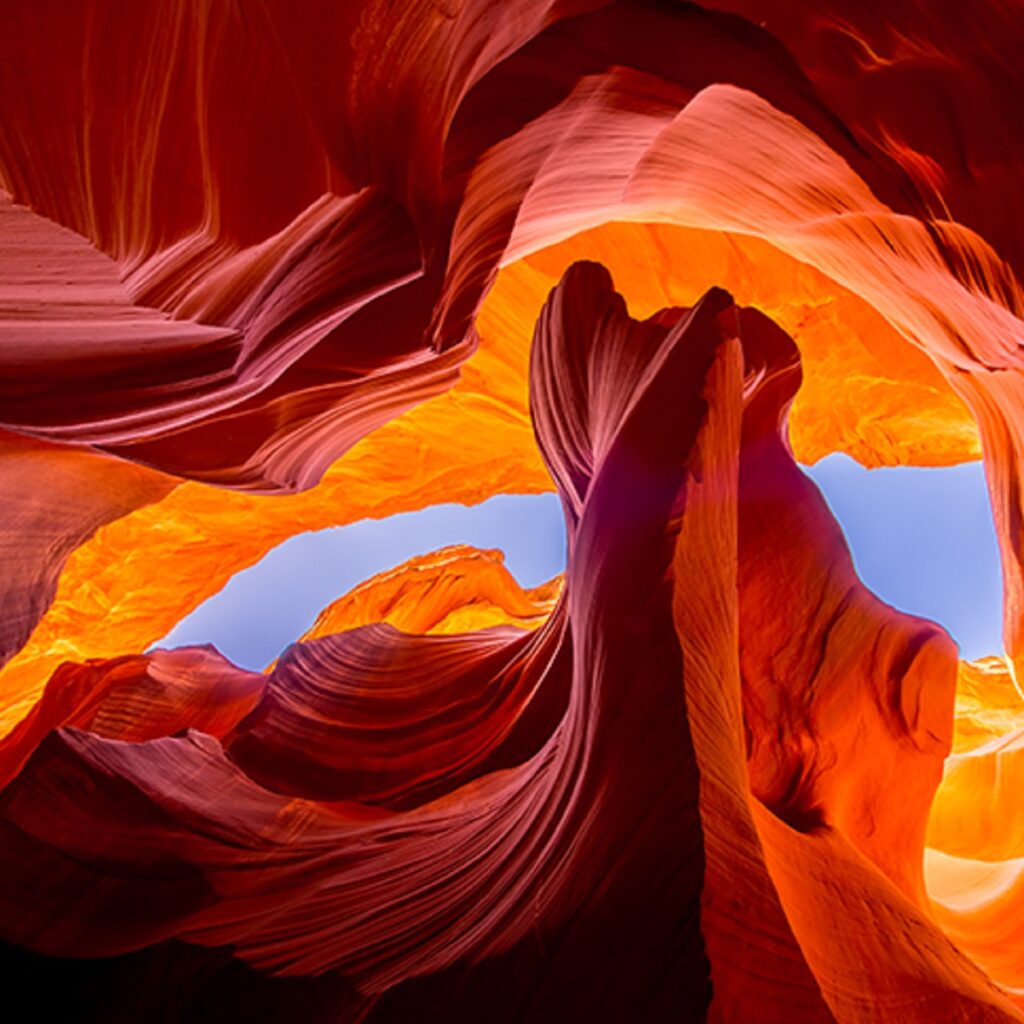 An image of Upper Antelope Canyon, looking up through the canyon walls at the sky