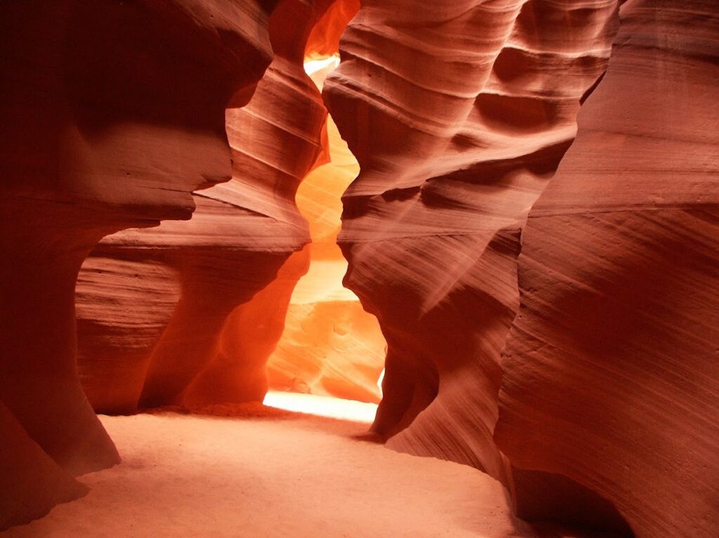 A dramatic picture lower antelope canyon, a burnt orange slot canyon with sun highlighting the walls